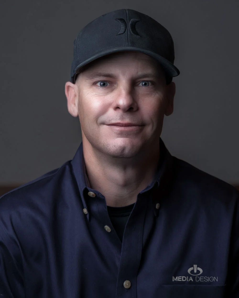 Media Design Inc, Headshots, Man in Navy Shirt and Hat