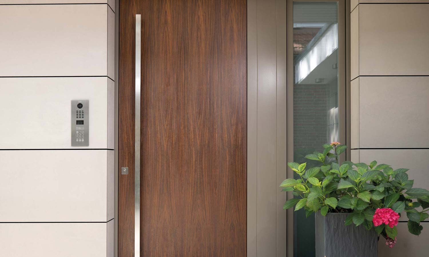 wooden door, silver handle, doorbird access panel on left