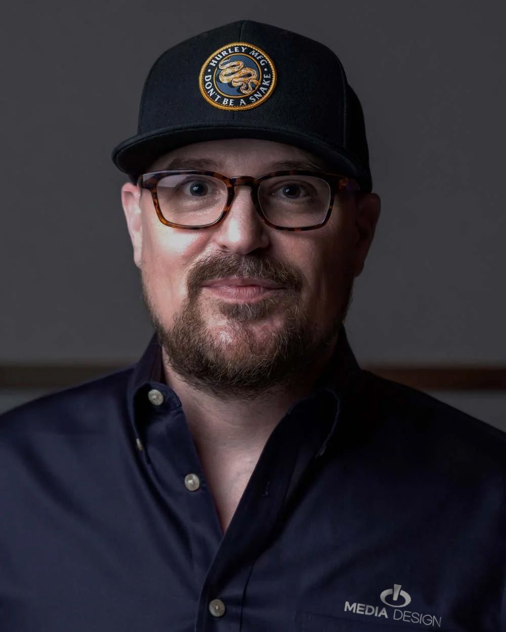 Media Design Inc, Headshots, Man in Navy Shirt and Hat